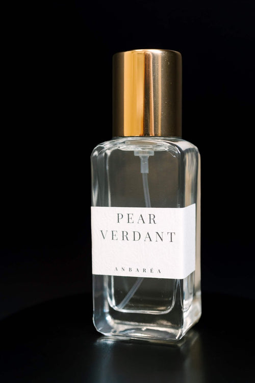 Pear Verdant Extrait de Parfum bottle with gold cap on a black background